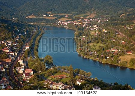European river Elbe in Dolni Zalezly and Sebuzi villages when viewed from Mlynaruv kamen lookout in czech central mountains tourist area at sommer sunset