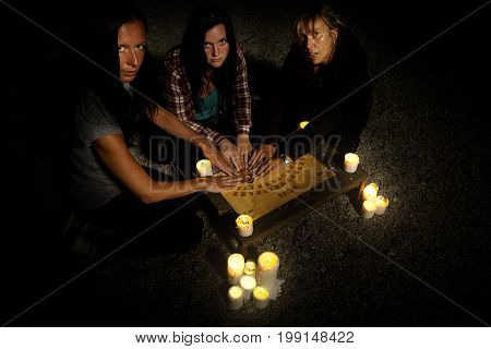 Woman spiritualists communicating with ghosts through spiritual board