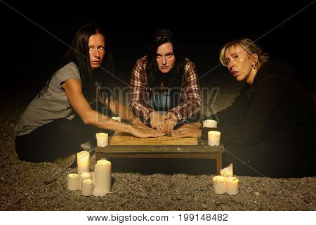 Woman spiritualists communicating with ghosts through spiritual board