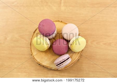 cooking, confectionery and baking concept - different macarons on wooden stand