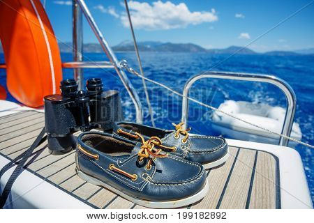 Navy top sider shoes with lifebuoy, binoculars on the wood background