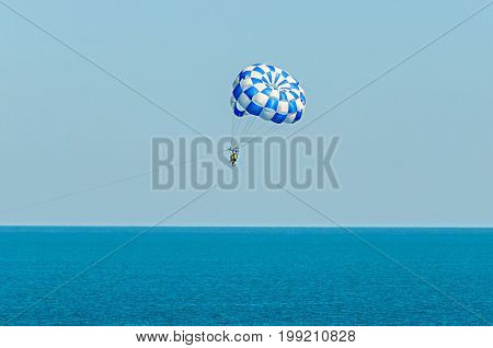 Blue Parasail Wing Pulled By A Boat In The Sea Water, Parasailing Also Known As Parascending Or Para