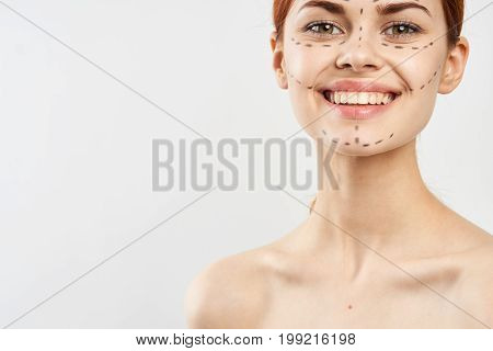 Young beautiful woman with contour for plastics on face on white isolated fn, smile, blank space for copy.