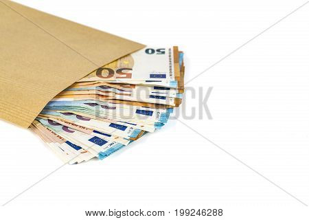Brown envelope full of euro banknotes bills onwhite background. Concept of corruption and bribery