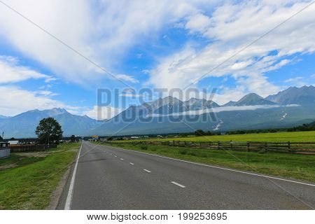 A long road to a fabulous beautiful place among the mountains of fields and meadows