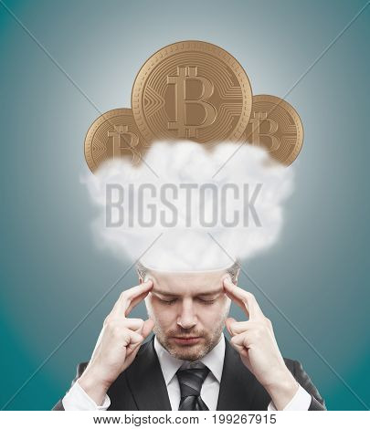 Handsome young european man thinking about bitcoins in clouds on blue background. E-commerce concept