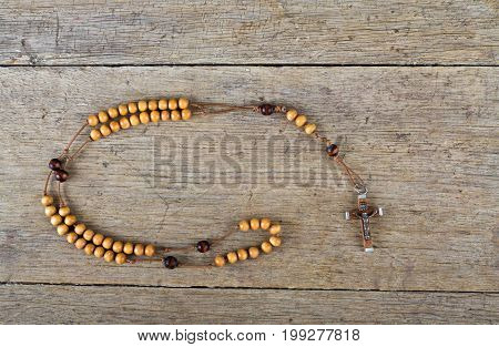 Rosary beads on the old wooden table