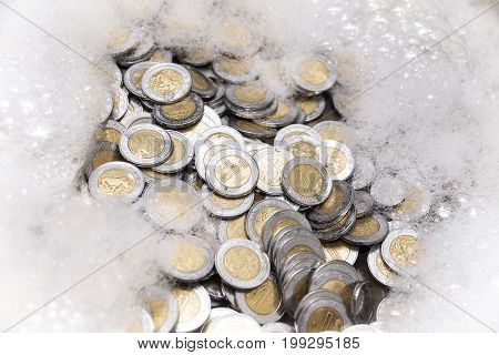 conceptual image of money laundering mexican pesos coins with soap foam
