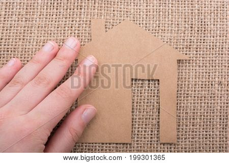 Hand Holding A Paper House On Canvas