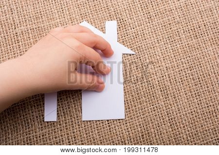Hand Holding A Aper House On A Canvas Background