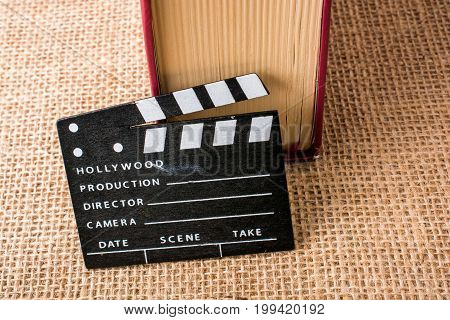 Movie Clapper Beside A Book On A Canvas