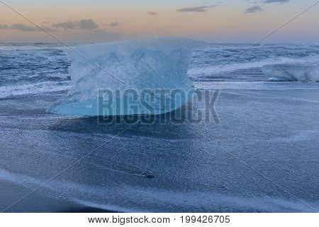 Ice braking on black sand beack seacoast skyline Iceland winter season natural landscape background