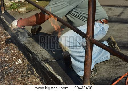 worker while burning the waterproof membrane on a roof