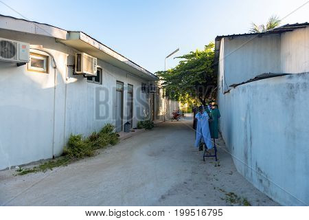 MAAFUSHI MALDIVES - MARCH 01 2016: Horizontal picture of common sand street with traditional houses in Maafushi Maldives