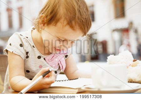 little child girl learns to write (prescool development training education concept)