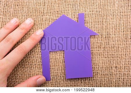 Hand Holding A Aper House On A Canvas Background