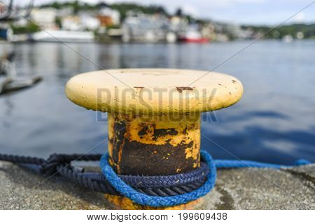 Yellow harbor mooring on the background of the summer marina on a sunny day.