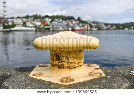 Yellow harbor mooring on the background of the summer marina on a sunny day.