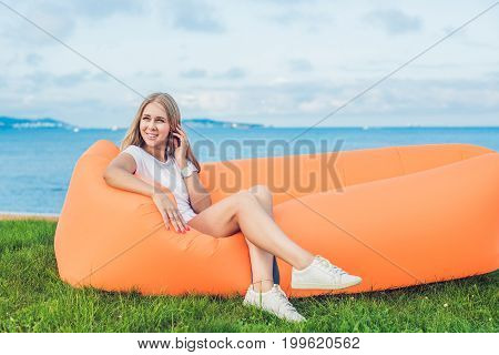 Young Woman Resting On An Air Sofa In The Park.