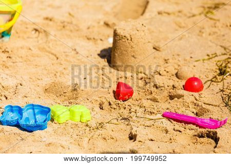 Summer kids toys on sandy beach druing summertime. Fun accessories objects concept.