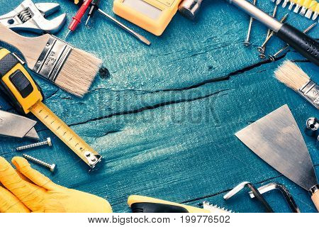 Set of various tools on blue wooden background. Construction and renovation concept with copy space
