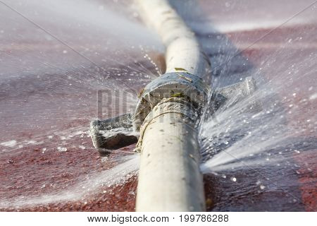 wasting water - water leaking from hole in a hose