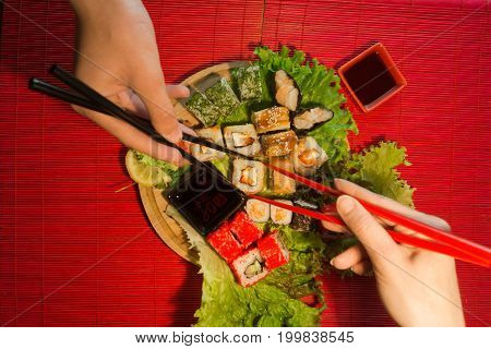 People eat sushi and rolls Japanese restaurant