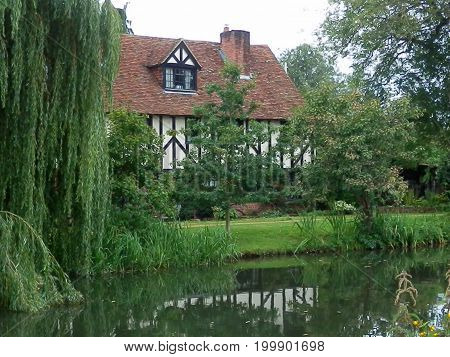 Aldermaston England - August 8 2017: Canal side cottage and weeping willow along the Kennet & Avon canal in Hampshire England