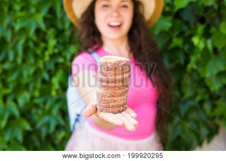Close-up of young female tourist with traditional czech dessert trdelnik in Prague. Czech Republic. Outdoor.