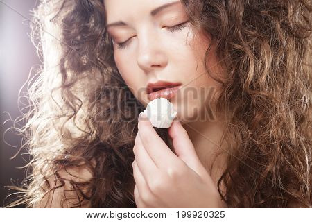 beauty portrait of a cute  girl in act to eat a candy with cocoanut