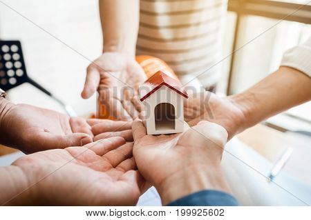 Teamwork Of Architectural Engineer Consulting On The Creation Of A Model Home, Hands Pointing To Min