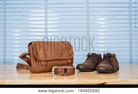 Men's Leather Fashion Clothing, Shoes, Bag And Belt On Plywood Table Desk In Business Office Room.