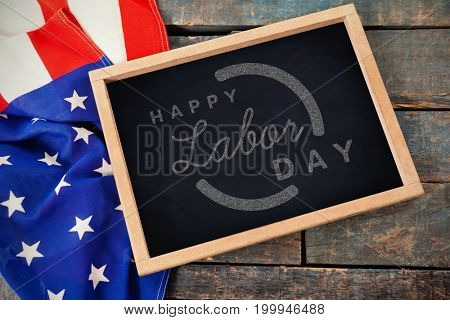 Digital composite image of happy labor day text with blue outline against high angle view of american flag with chalkboard