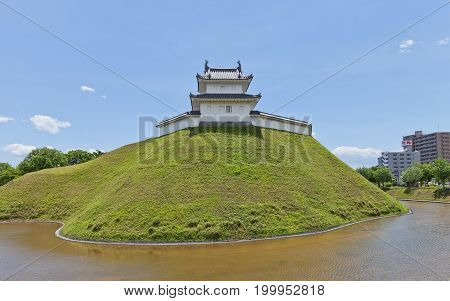UTSUNOMIYA JAPAN - JUNE 2 2017: Reconstructed moat earthen wall and Seimeidai Turret of Utsunomiya Castle Japan. Castle was founded in 1062 destroyed in war of 1868 and reconstructed in 2007