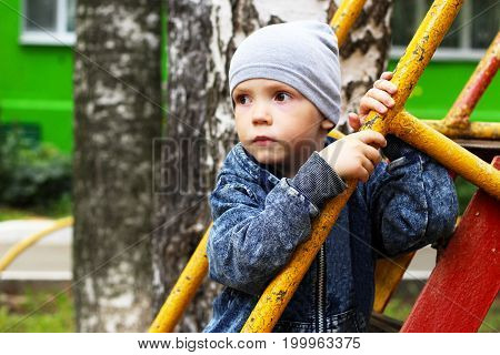 Portrait Of Little Boy On Nature Background Among Birches