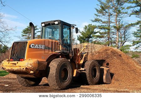 Rowley, Massachusetts, April 29, 2019:  The Case 4 Wheel Drive Tractor With A Bucket Scooping Saw Du