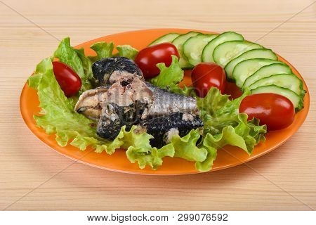 Pieces Of Sardine Iwashi On Lettuce Leaves With Red Tomatoes.