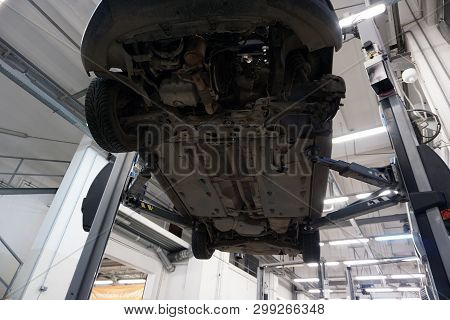 Car Raised On Car Lift In Autoservice.car Lifted In Automobile Service For Fixing. Maintenance And R