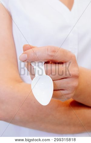 A Young Woman Doctor Distributes Portions Of Drugs In The Hospital, Determining Each Put Milliliters