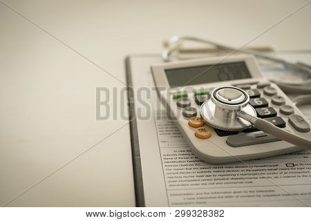 Medical Expenses Debt. Stethoscope On Calculator With Medical Bill.