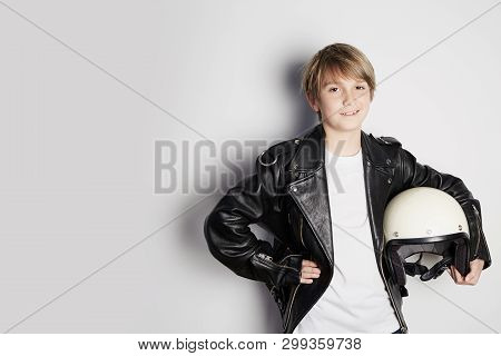 Portrait Of Young Cool Beautiful Teen Kid In Black Leather Jacket And Holding Hand White Moto Helmet