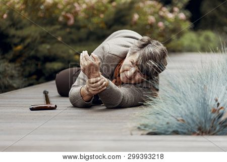 Weak Elderly Woman Lying On The Floor And Waiting For Help After Heart Attack