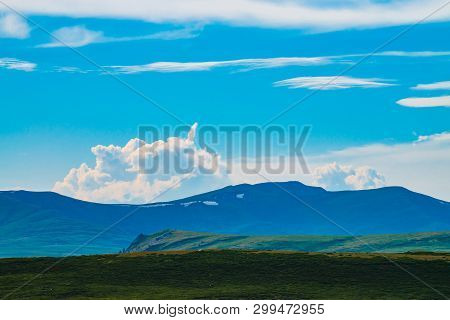 Spectacular View Of Giant Mountains With Snow. Huge Cloud Above Mountain. Big Rocky Cliff Above Abys