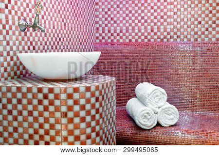 Traditional Turkish Hamam With Stone Walls, Sink And Stack Of  Clean Towels