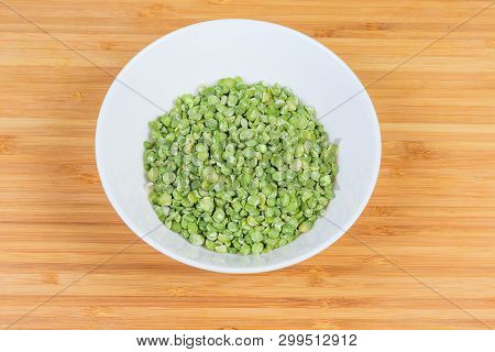 Raw Green Variety Of The Split Peas In White Bowl On A Bamboo Wooden Surface