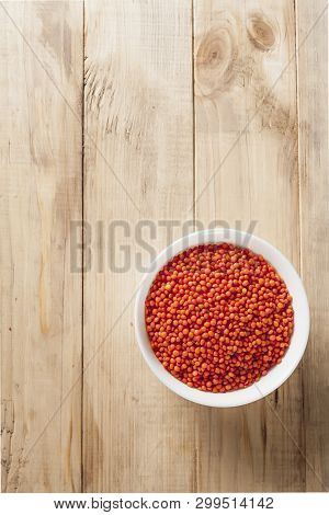 Red Lentils In A White Bowl On A Wooden Table