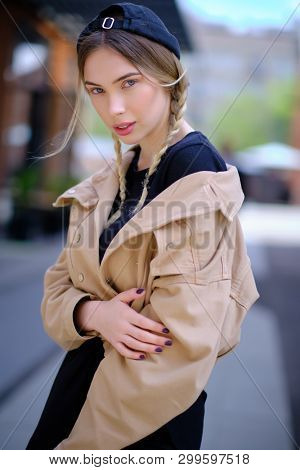 Portrait of blonde girl with flyaway hair in the street background 