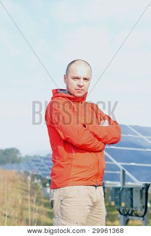 Engenheiro masculino no local de trabalho, a fábrica de painéis solares industy no fundo