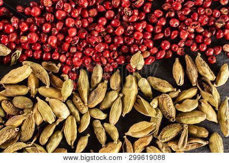 Closeup Of Lot Of Whole True Cardamom Pod And Peruvian Pink Pepper Flatlay On Grey Stone