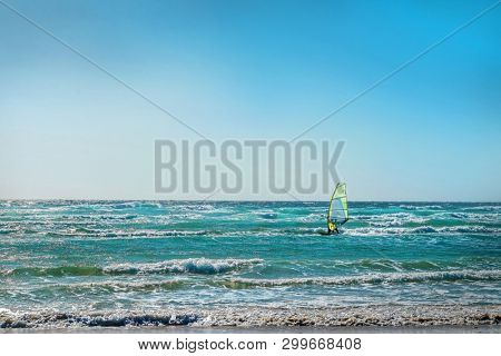 Windsurfer on the waves. Ocean coastline on the island. Sport, surf, windsurf, leasure, holidays concept.